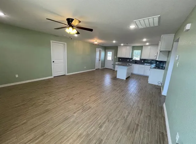 a view of kitchen and living room with wooden floor