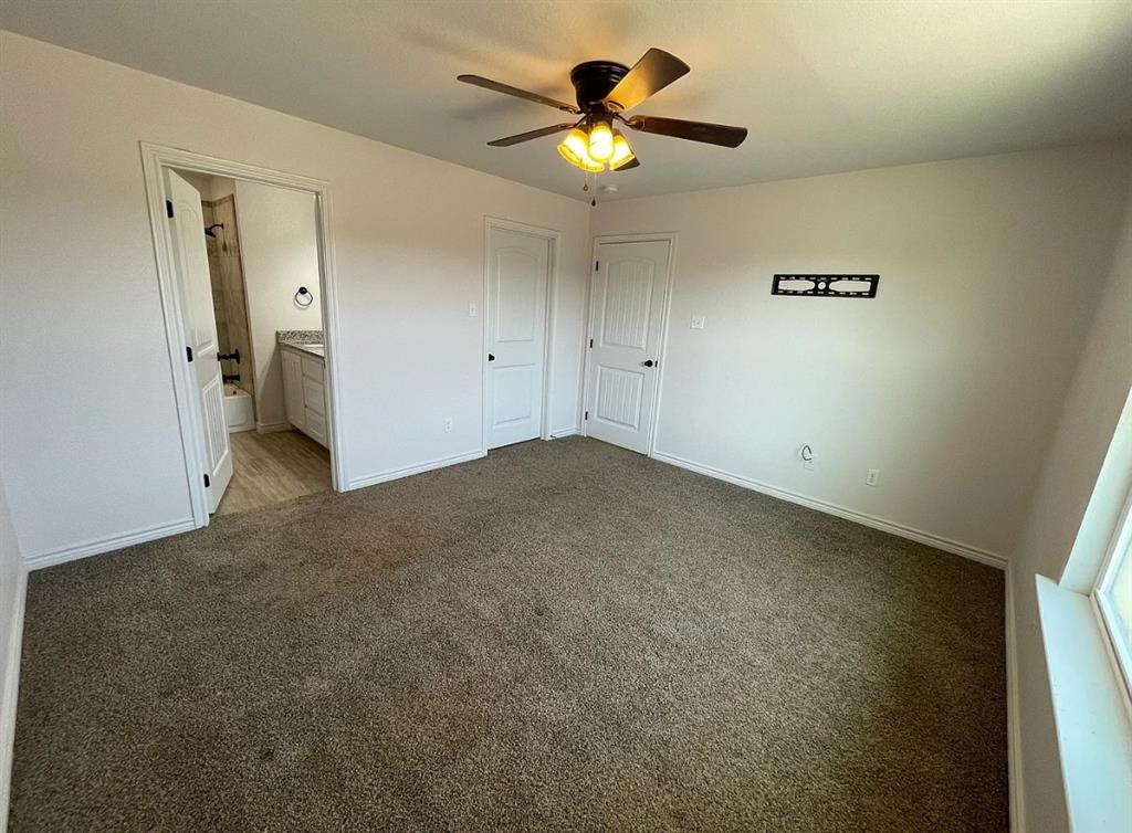 109 Spruce Tree Court Poolville, TX 76487 - Photo 10 of 21 an empty room with a fan and a ceiling fan