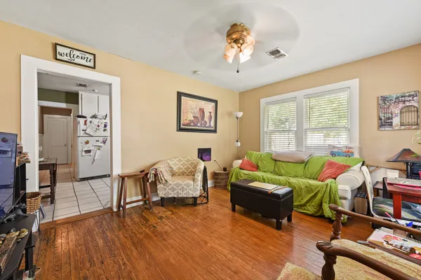 a living room with furniture and a wooden floor