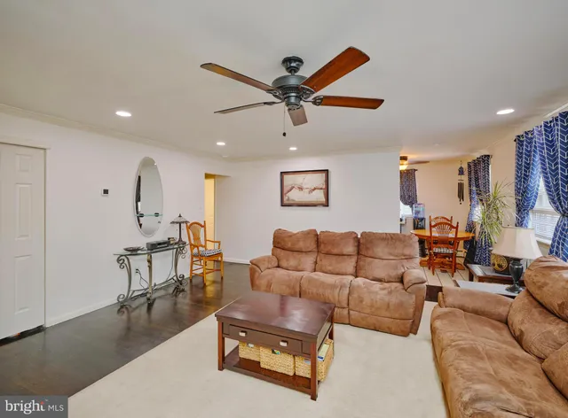 a living room with furniture and a view of kitchen