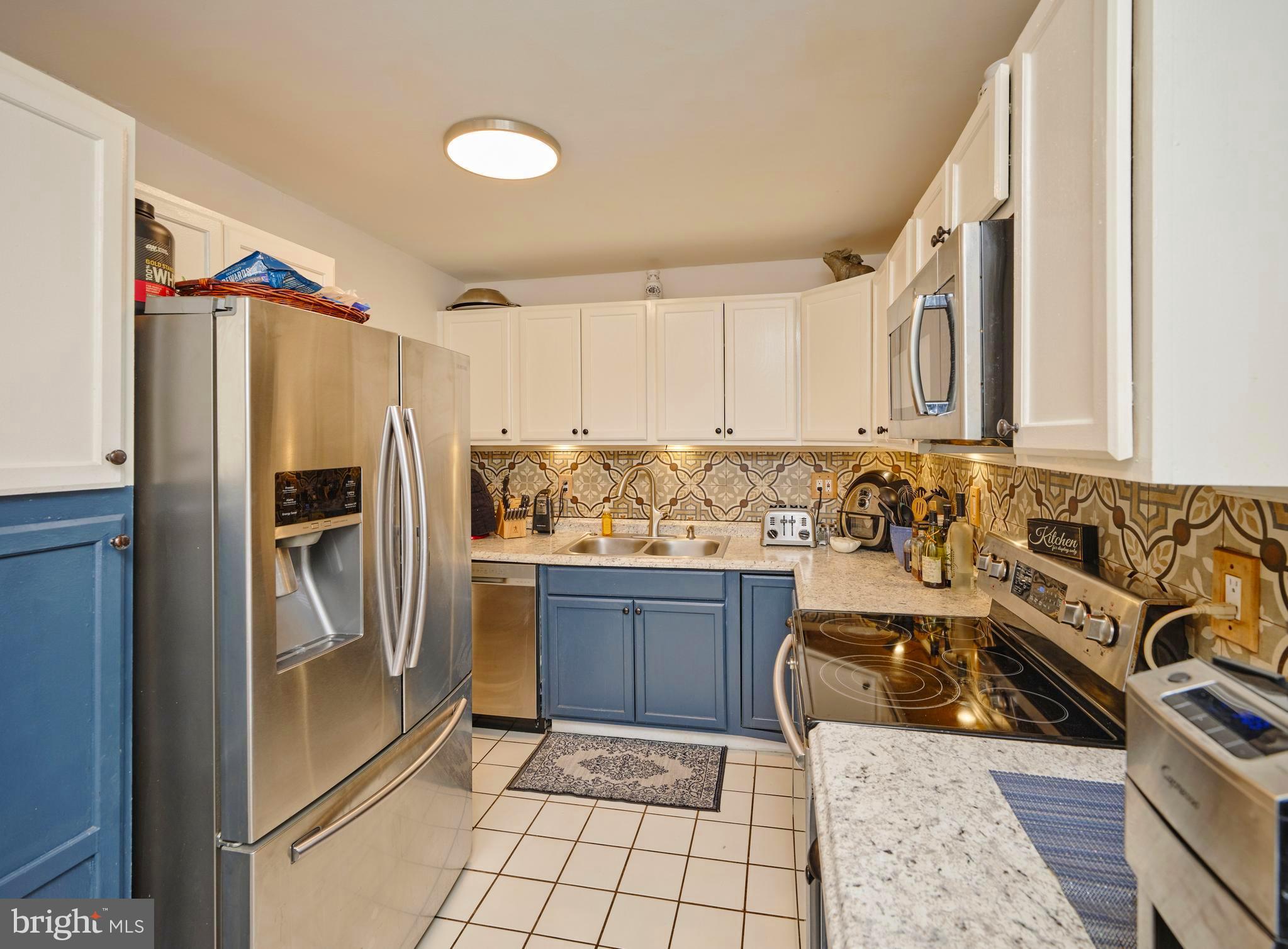 403 South Main Street, Unit S201 Doylestown, PA 18901 - Photo 7 of 13 a kitchen with granite countertop a refrigerator and a stove