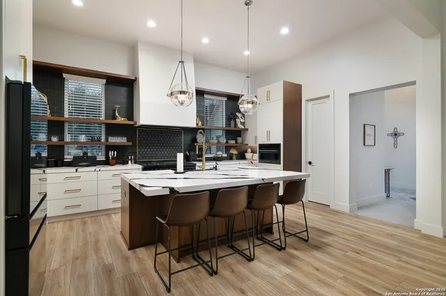 a kitchen with stainless steel appliances granite countertop a table chairs sink and cabinets