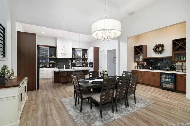 a view of a dining room with furniture a chandelier and wooden floor