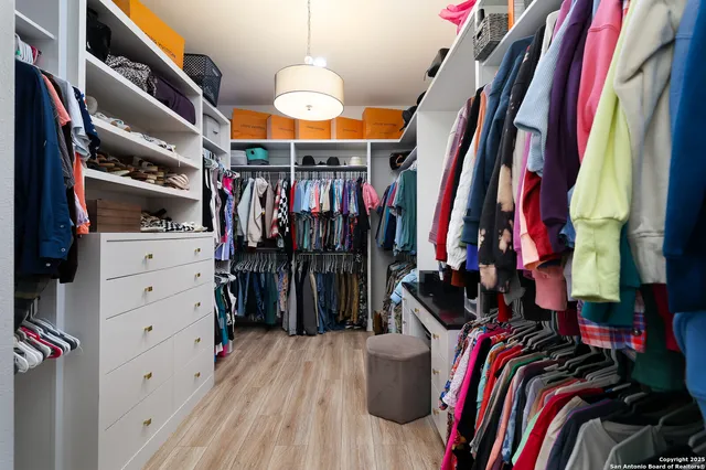 a view of walk in closet with clothes