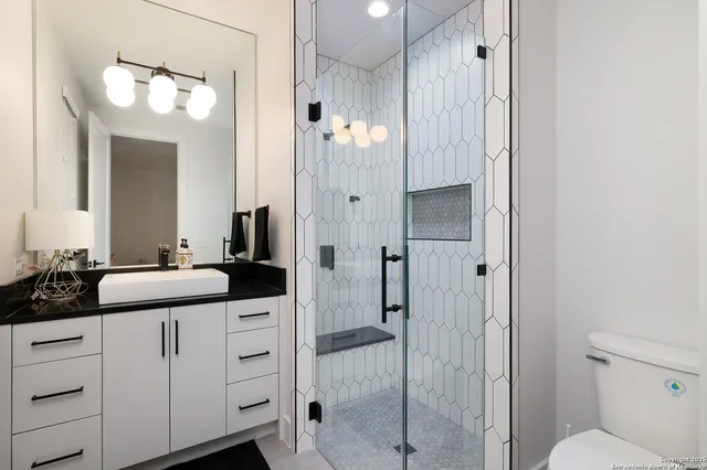 a bathroom with a double vanity sink mirror and toilet