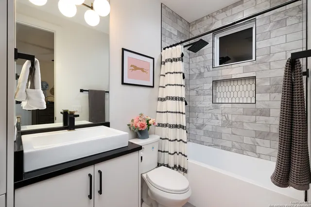 a bathroom with a sink a toilet a mirror and shower