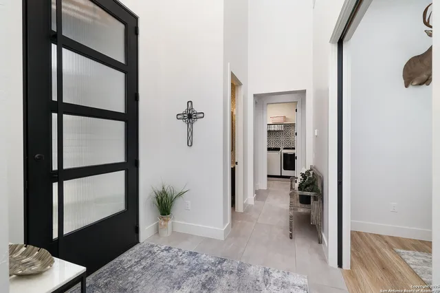 a view of a hallway with wooden floor and a livingroom
