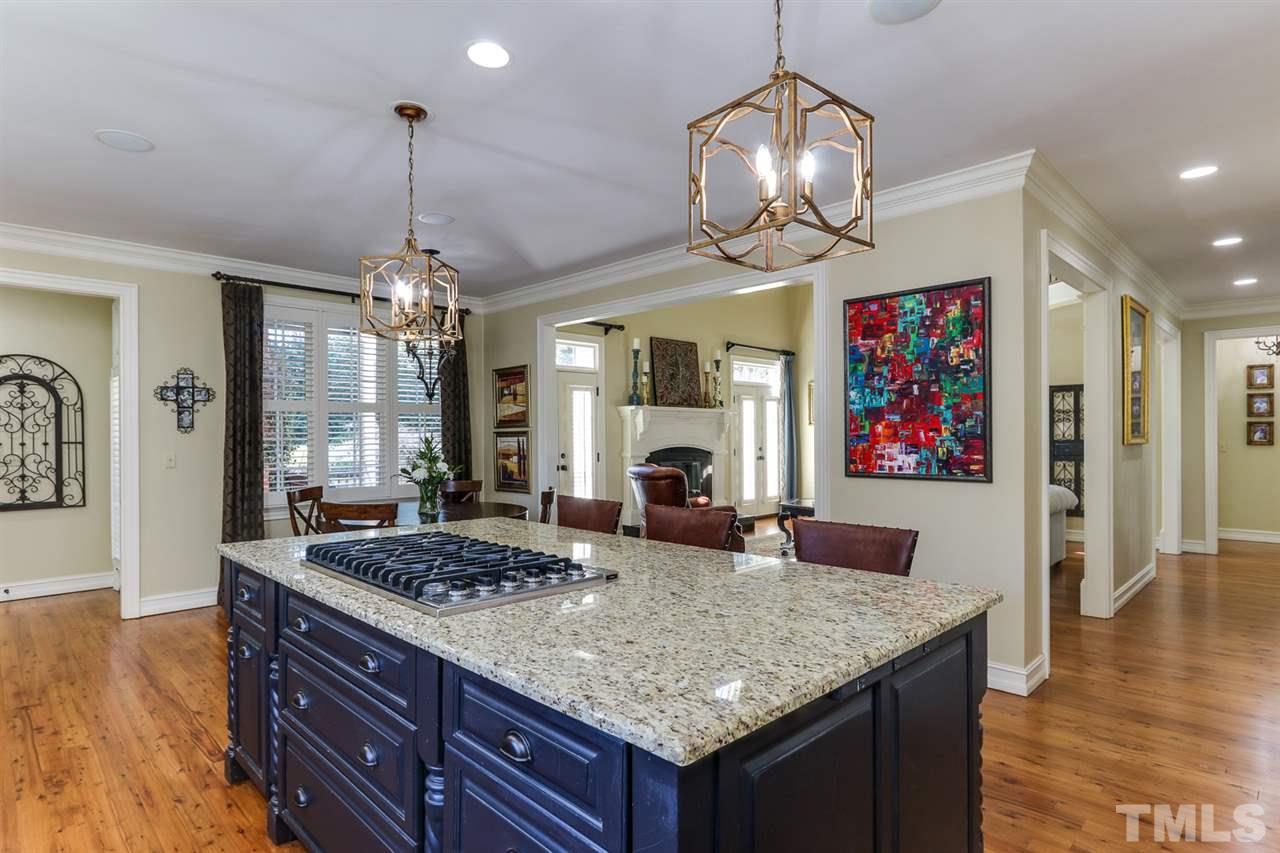 3329 Harden Road Raleigh, NC 27607 - Photo 11 of 29 a large kitchen with granite countertop a stove and a wooden floor