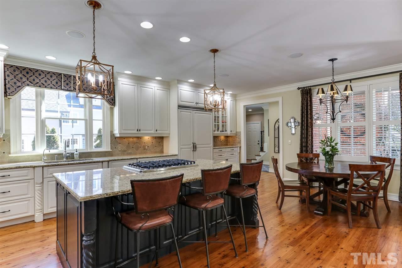 3329 Harden Road Raleigh, NC 27607 - Photo 10 of 29 a kitchen with stainless steel appliances granite countertop dining table chairs and wooden floor