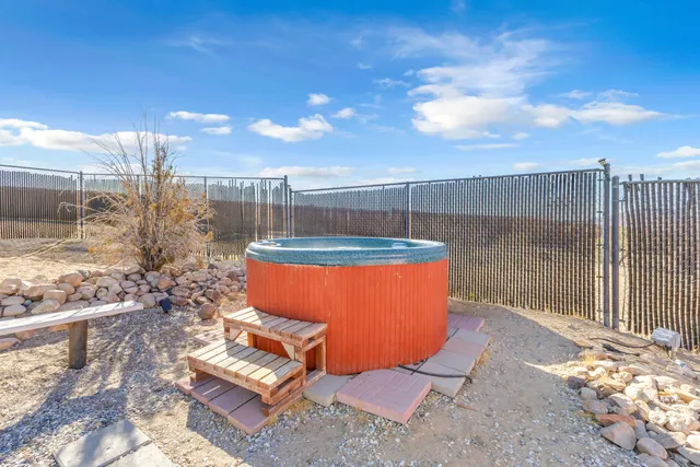a backyard of a house with wooden chairs