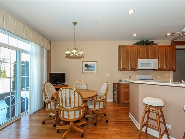 804 Stone Canyon Circle Inverness, IL 60010 - Photo 10 of 30 a view of a dining room with furniture a chandelier and wooden floor