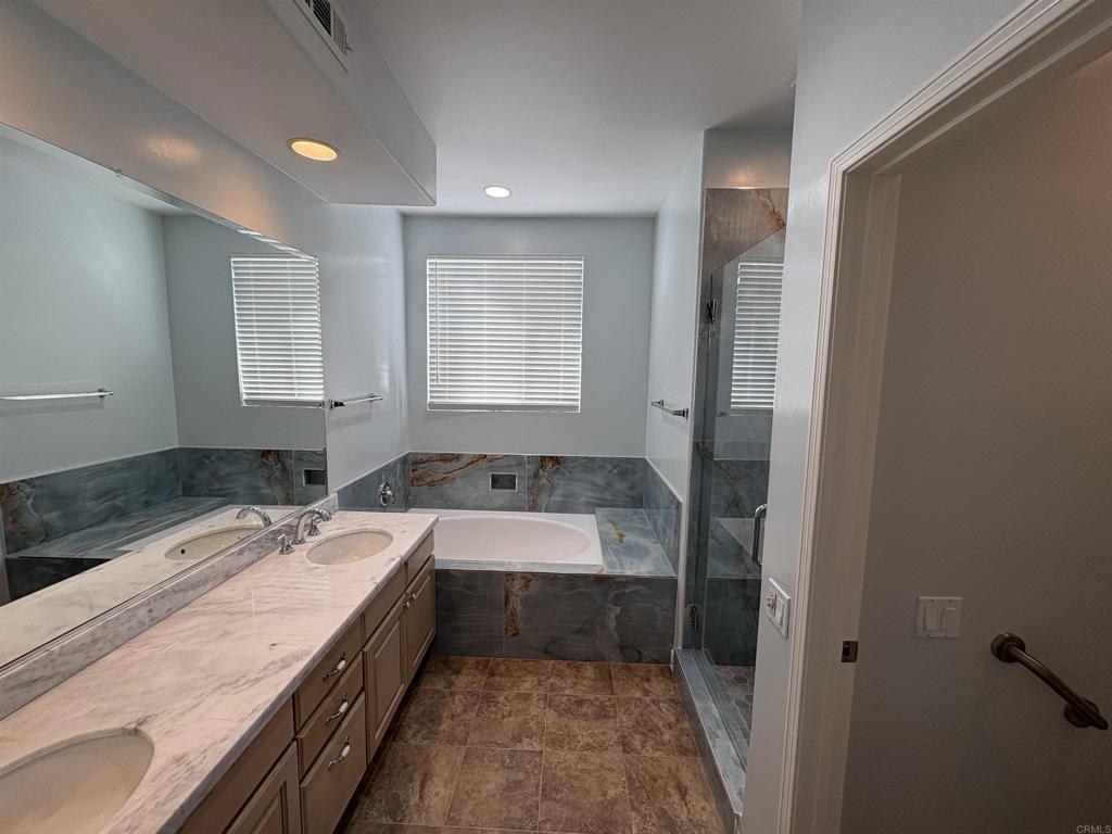 3365 Genoa Way, Unit 138 Oceanside, CA 92056 - Photo 21 of 34 a bathroom with a granite countertop sink a mirror and a bathtub