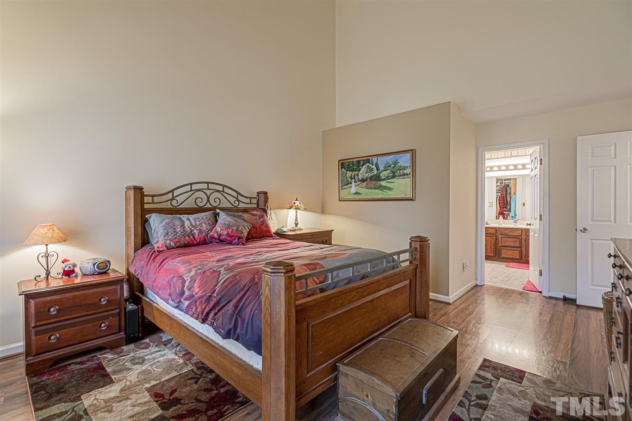 4248 Birmingham Way Raleigh, NC 27604 - Photo 17 of 29 a bedroom with a bed and wooden floor