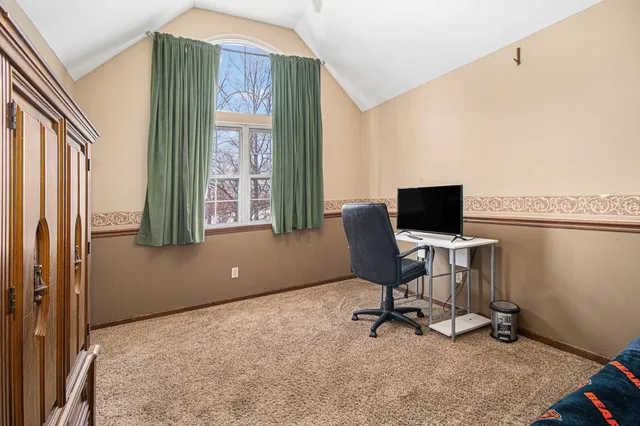 a view of a workspace with furniture and a window