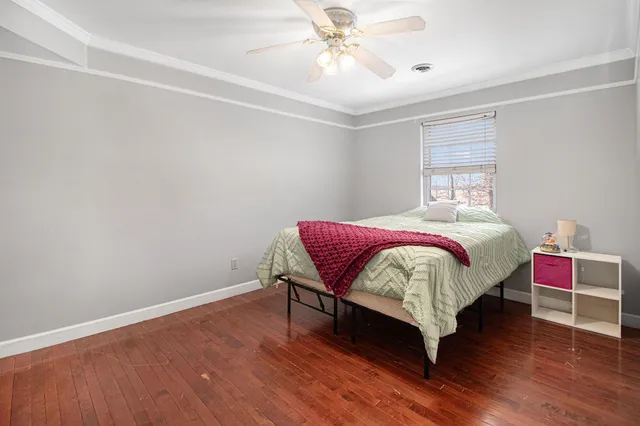 a bedroom with a bed table and two window