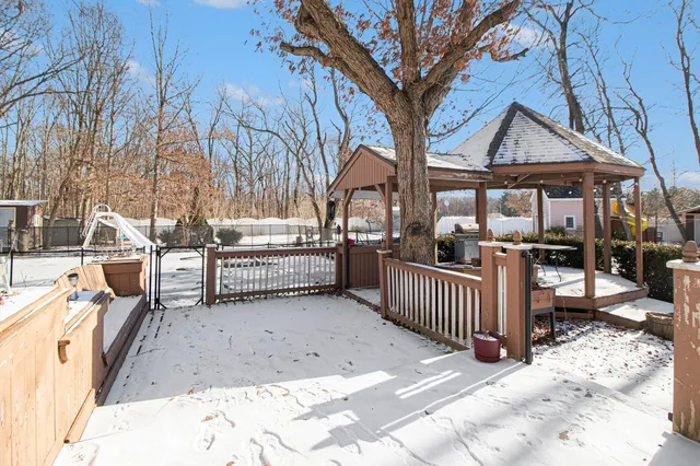 a view of a house with a wooden fence and a snow
