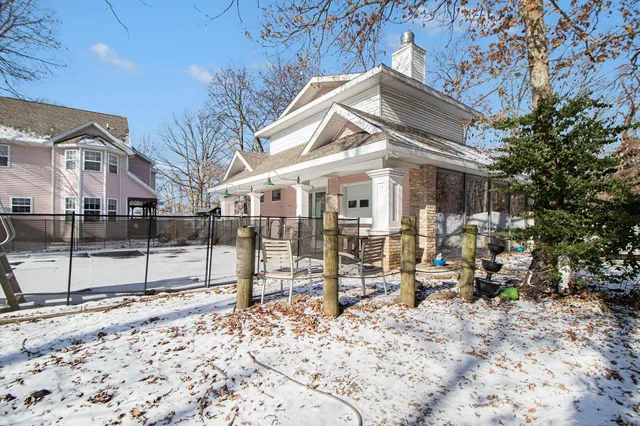 a view of a patio with couches table and chairs under an umbrella with wooden floor