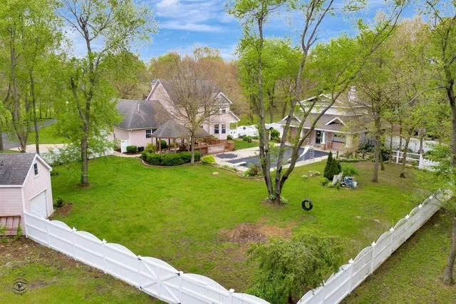 an aerial view of residential houses with outdoor space and trees