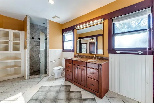 a bathroom with a granite countertop sink toilet a mirror and a shower