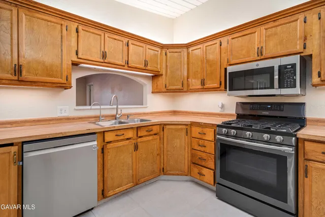 a kitchen with stainless steel appliances granite countertop a stove a sink and a microwave