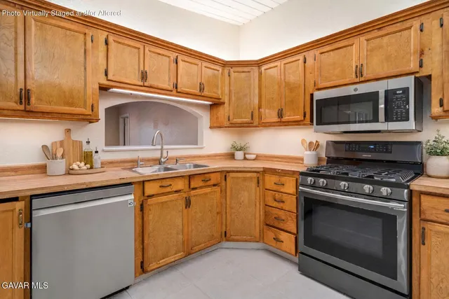a kitchen with granite countertop a refrigerator stove top oven and sink