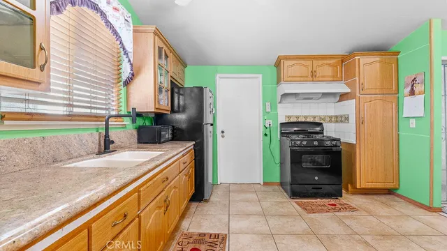a kitchen with stainless steel appliances granite countertop a refrigerator and a stove top oven