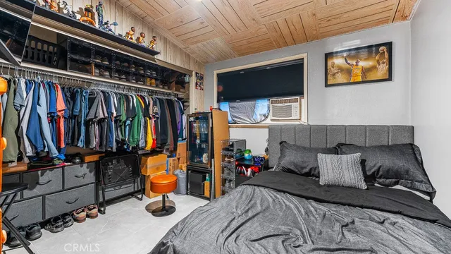 a bedroom with a bed a flat screen tv and dresser