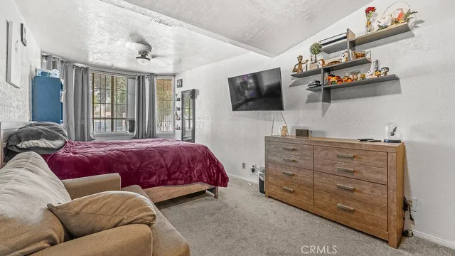 a spacious bedroom with a bed a couch and dresser