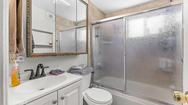 a bedroom with a bed wooden floor and flat screen tv