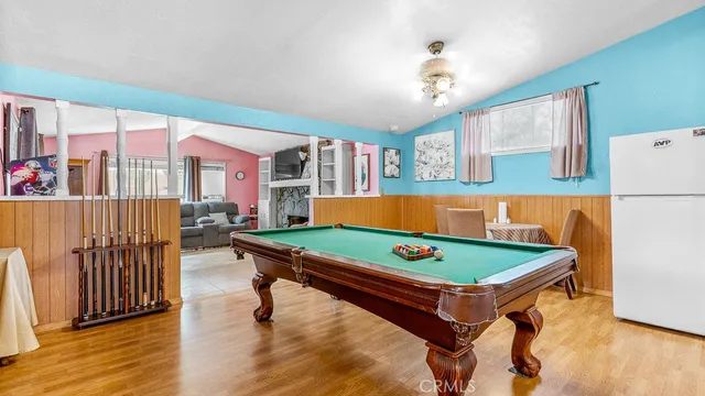 a room with furniture pool table and wooden floor