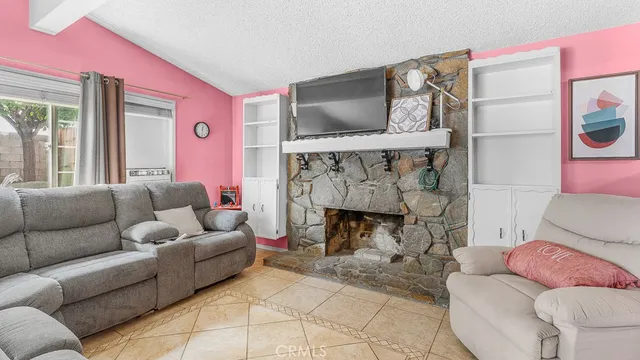 a living room with furniture a flat screen tv and a fireplace