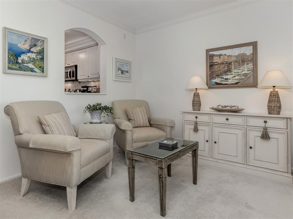 230 Santa Maria Street, Unit 330 Venice, FL 34285 - Photo 11 of 59 a living room with furniture and paintings on the wall