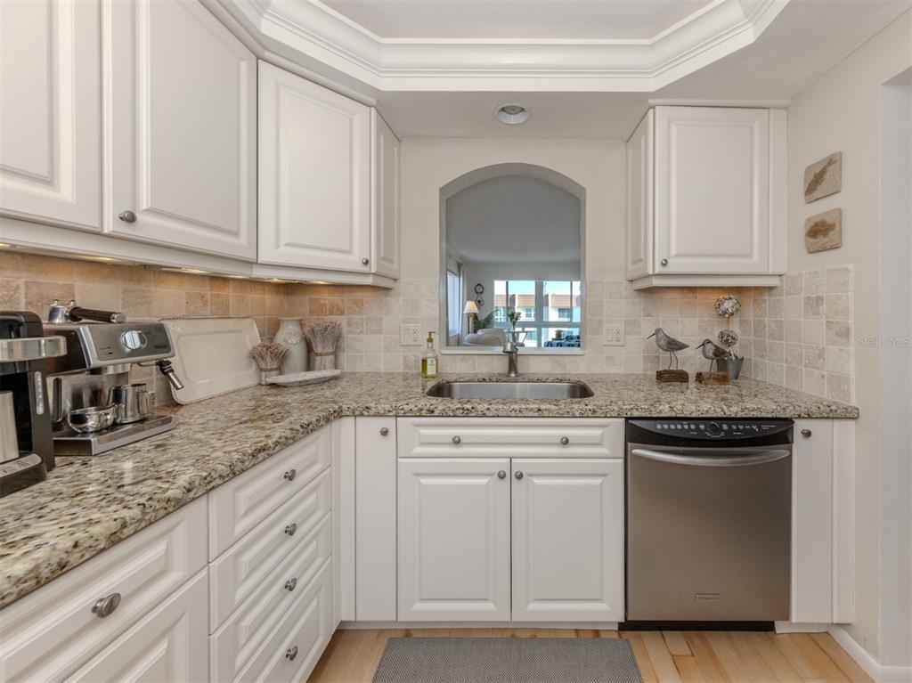 230 Santa Maria Street, Unit 330 Venice, FL 34285 - Photo 15 of 59 a kitchen with granite countertop white cabinets and white appliances