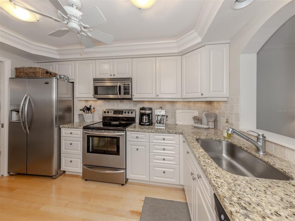 230 Santa Maria Street, Unit 330 Venice, FL 34285 - Photo 16 of 59 a kitchen with granite countertop a refrigerator stove and sink