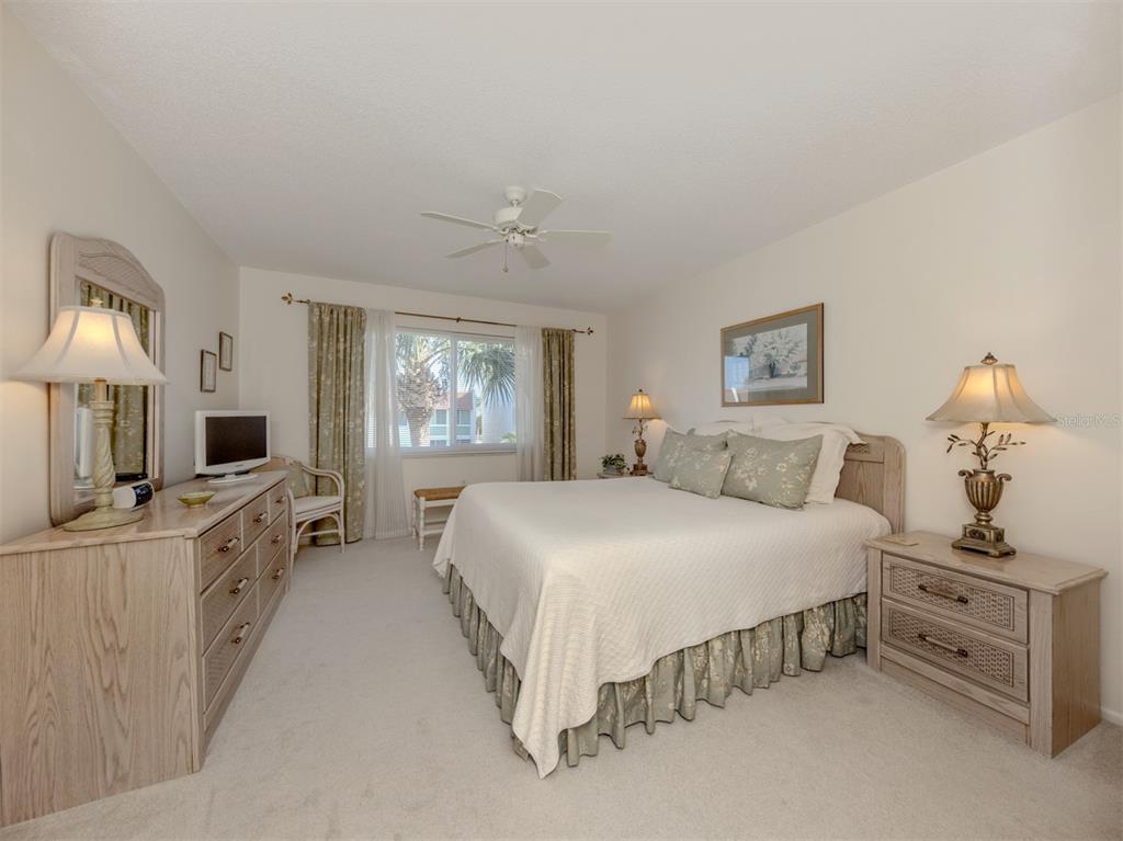 230 Santa Maria Street, Unit 330 Venice, FL 34285 - Photo 19 of 59 a spacious bedroom with a bed and a dresser