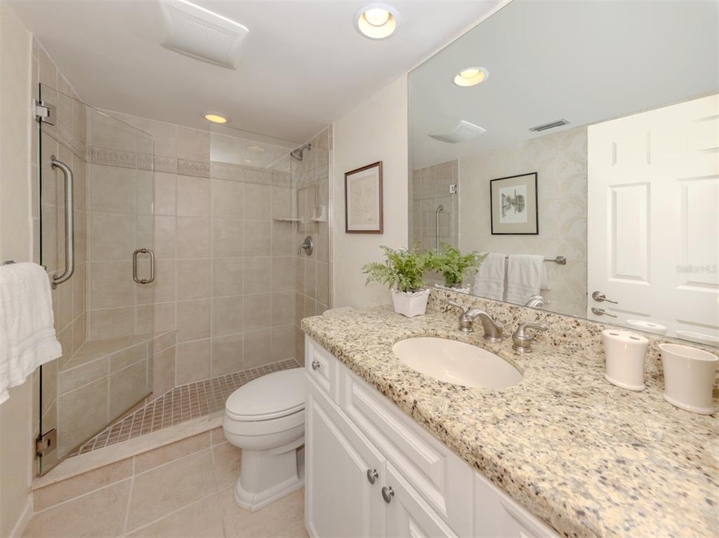 230 Santa Maria Street, Unit 330 Venice, FL 34285 - Photo 20 of 59 a bathroom with a granite countertop sink a toilet and shower