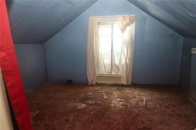 a room with water heater and wooden cabinets