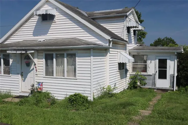 a view of a house with brick walls and a yard