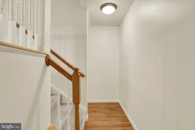 a view of a hallway with wooden floor and staircase
