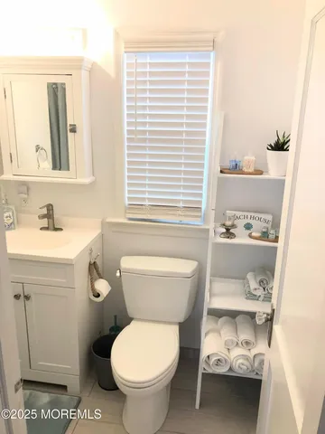 a bathroom with a toilet a sink and a window