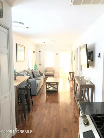 a living room with furniture a wooden floor and next to a window