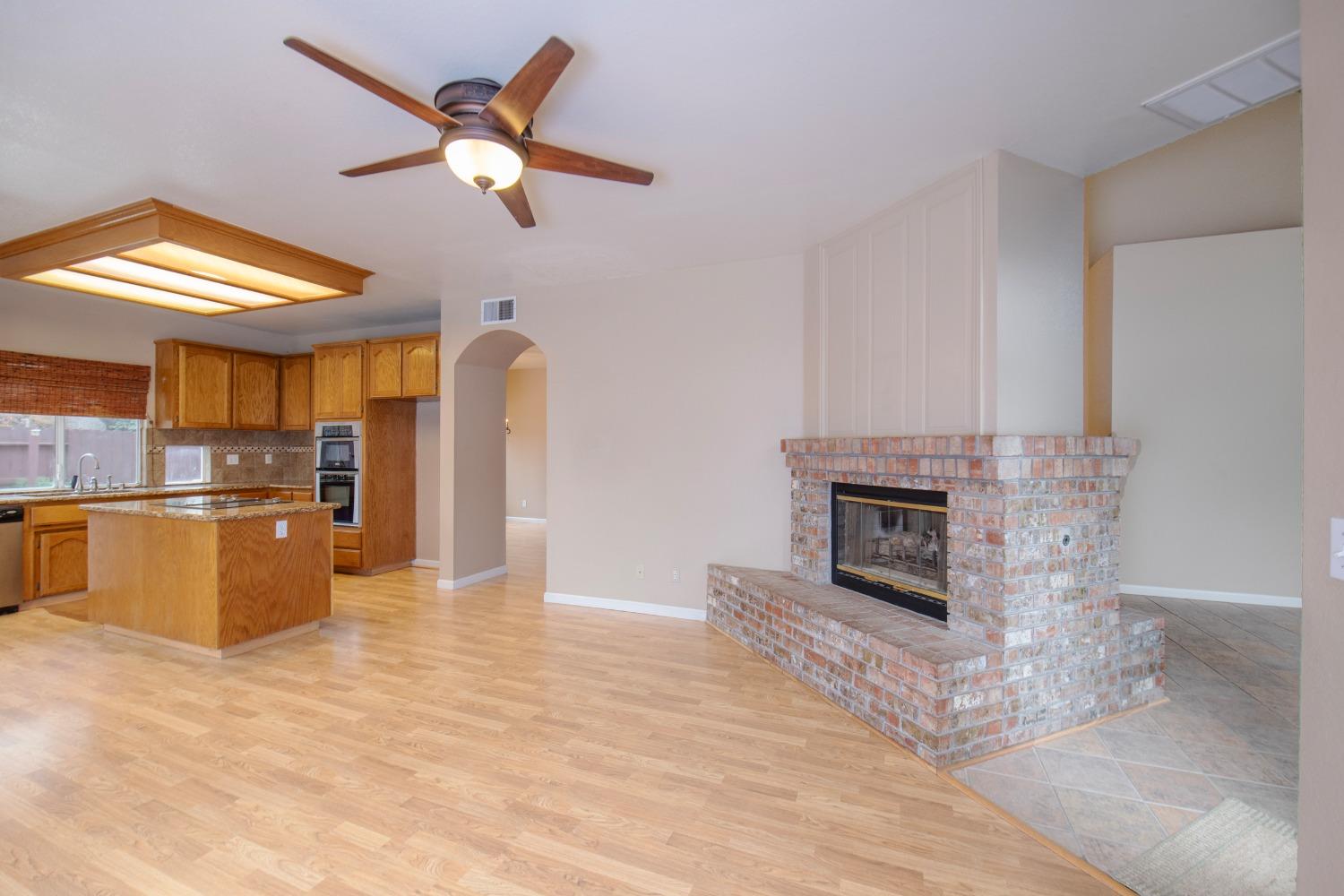1361 Birch Avenue Clovis, CA 93611 - Photo 16 of 43 a living room with stainless steel appliances kitchen island granite countertop furniture and a fireplace