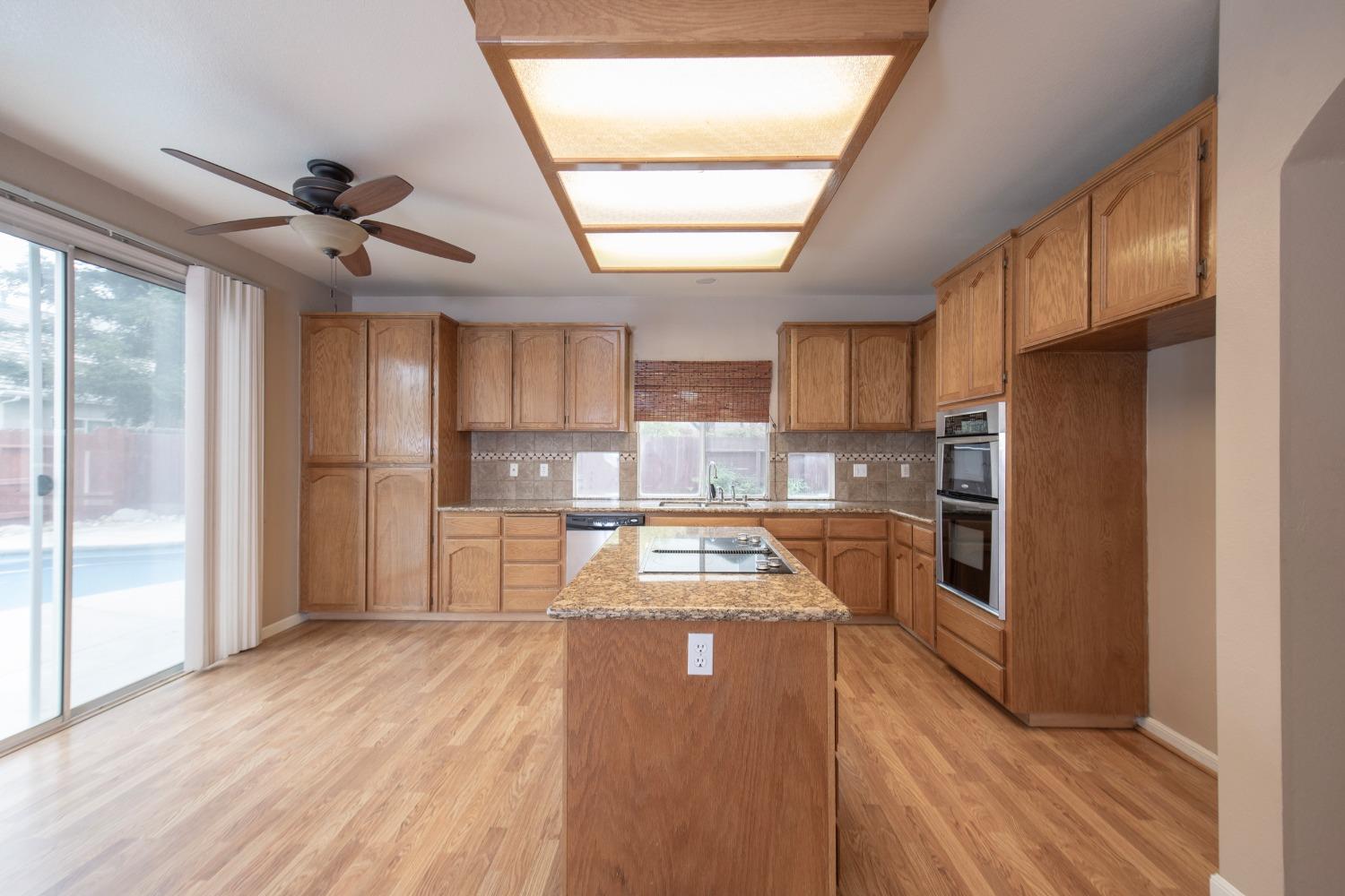 1361 Birch Avenue Clovis, CA 93611 - Photo 18 of 43 a large kitchen with granite countertop a large counter top stainless steel appliances and cabinets