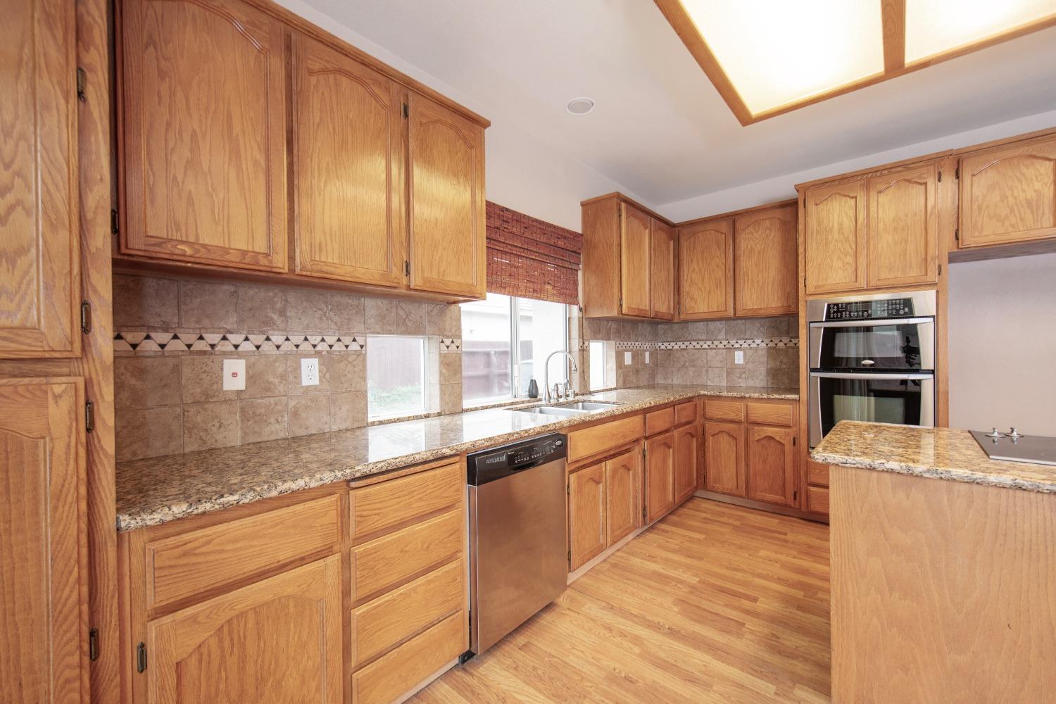 1361 Birch Avenue Clovis, CA 93611 - Photo 19 of 43 a kitchen with stainless steel appliances granite countertop a refrigerator sink and cabinets