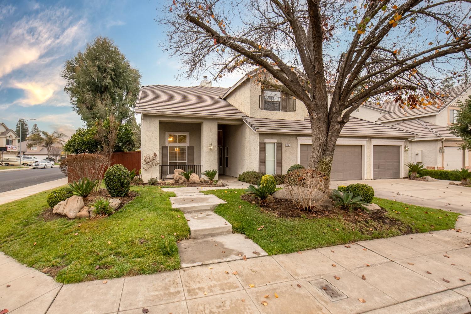 1361 Birch Avenue Clovis, CA 93611 - Photo 2 of 43 a front view of a house with a garden and trees