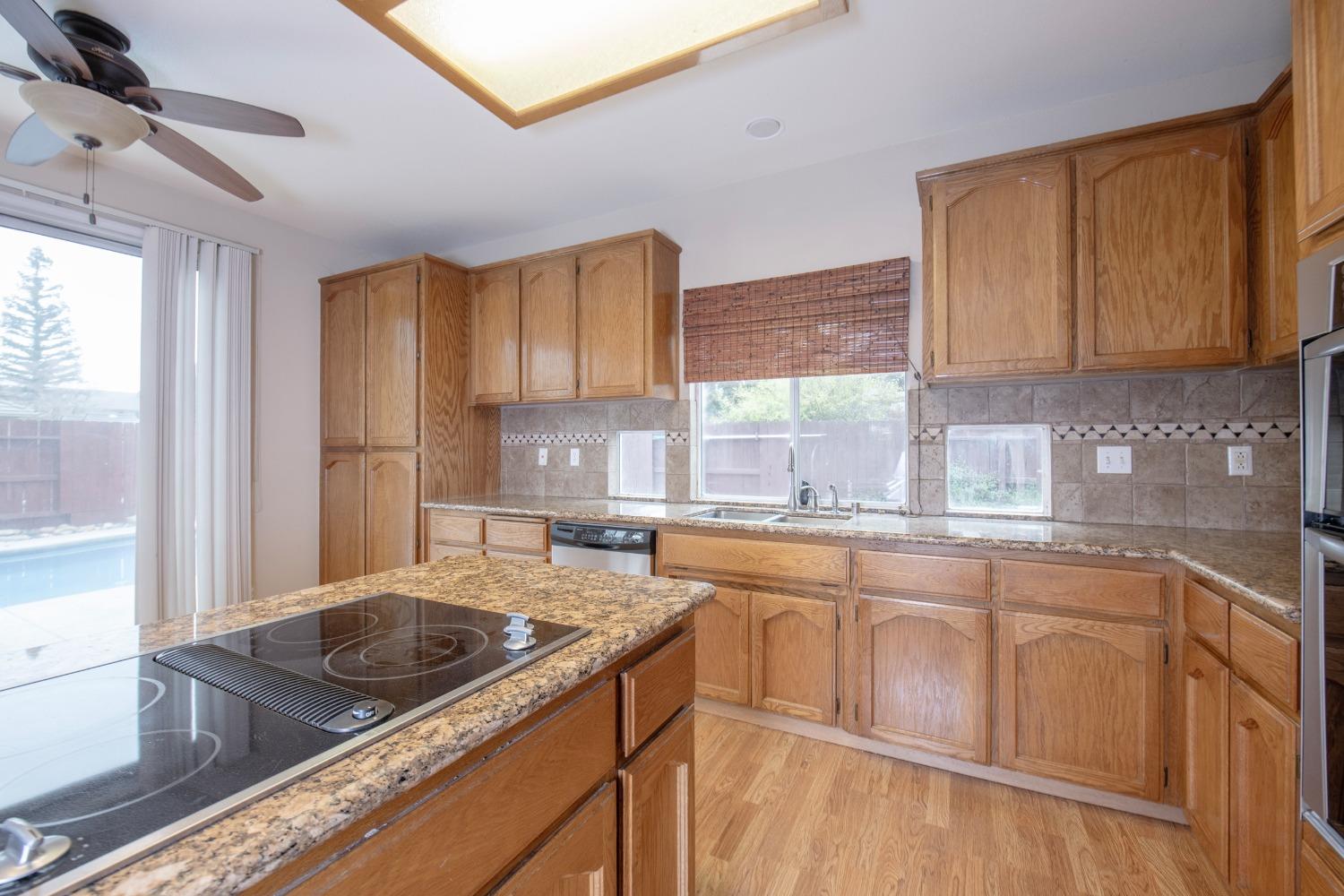 1361 Birch Avenue Clovis, CA 93611 - Photo 21 of 43 a kitchen with stainless steel appliances granite countertop a sink stove and cabinets