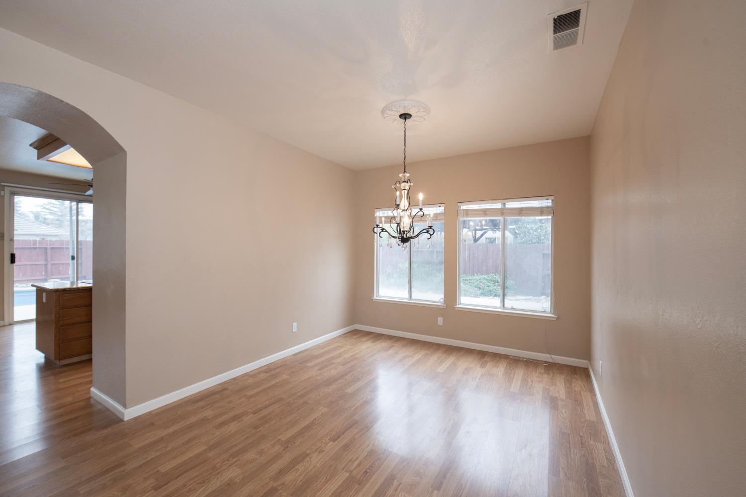 1361 Birch Avenue Clovis, CA 93611 - Photo 23 of 43 an empty room with wooden floor chandelier and outdoor view