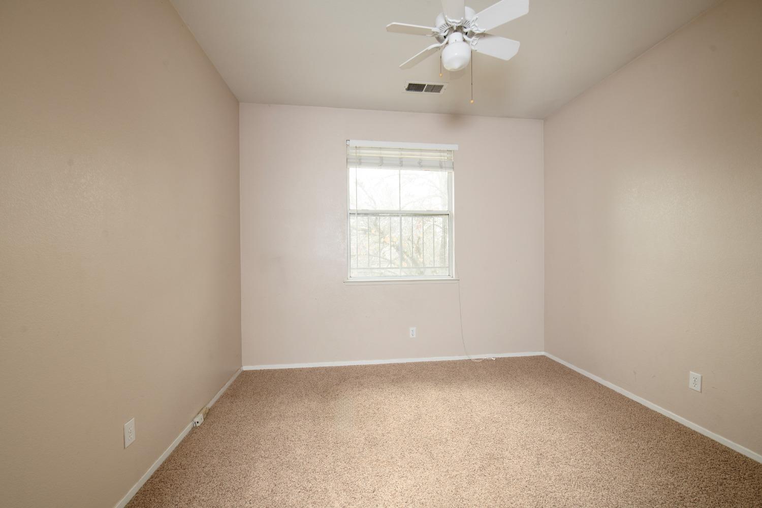 1361 Birch Avenue Clovis, CA 93611 - Photo 29 of 43 an empty room with a window and a chandelier fan