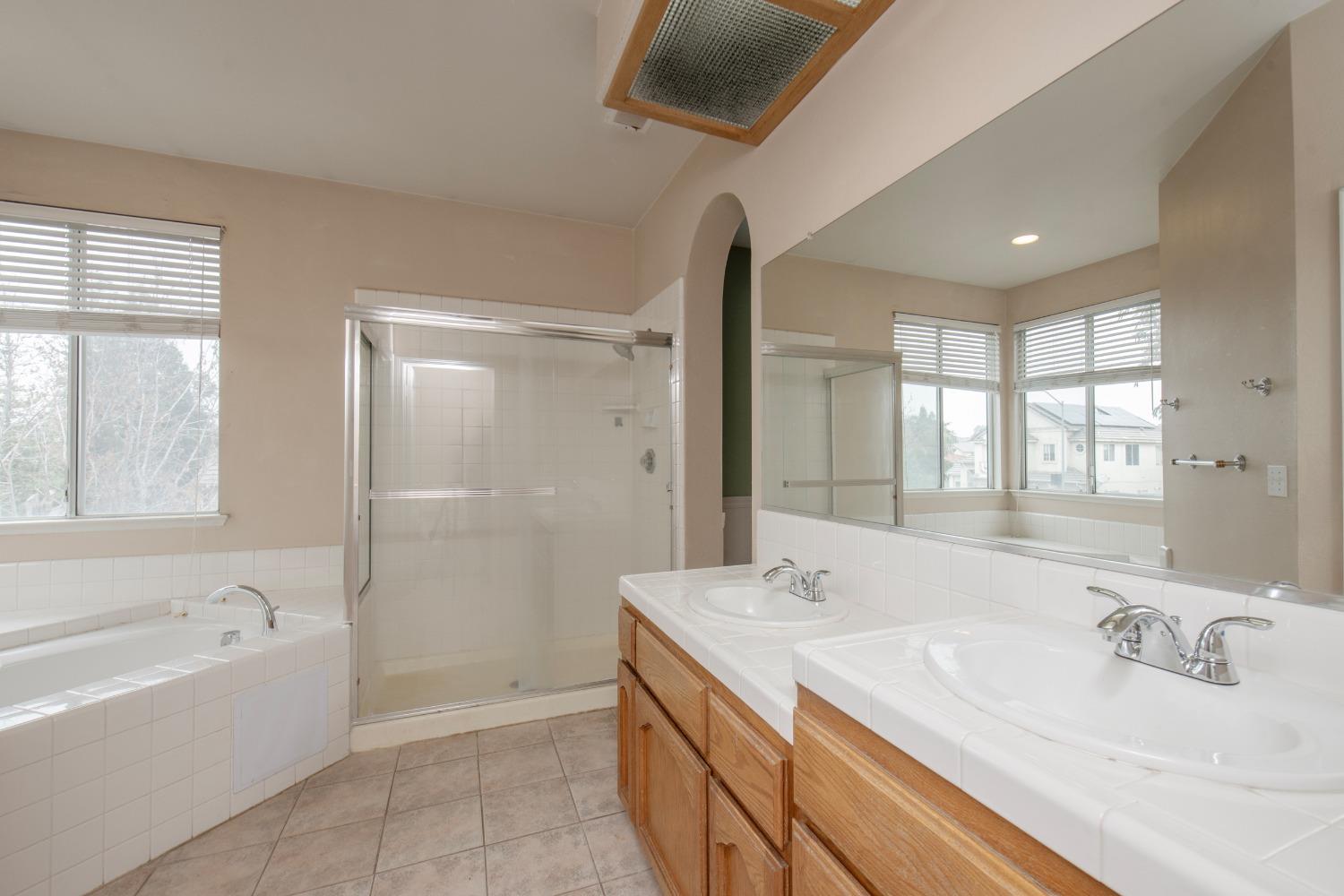 1361 Birch Avenue Clovis, CA 93611 - Photo 37 of 43 a spacious bathroom with a granite countertop tub sink a mirror and a bathtub
