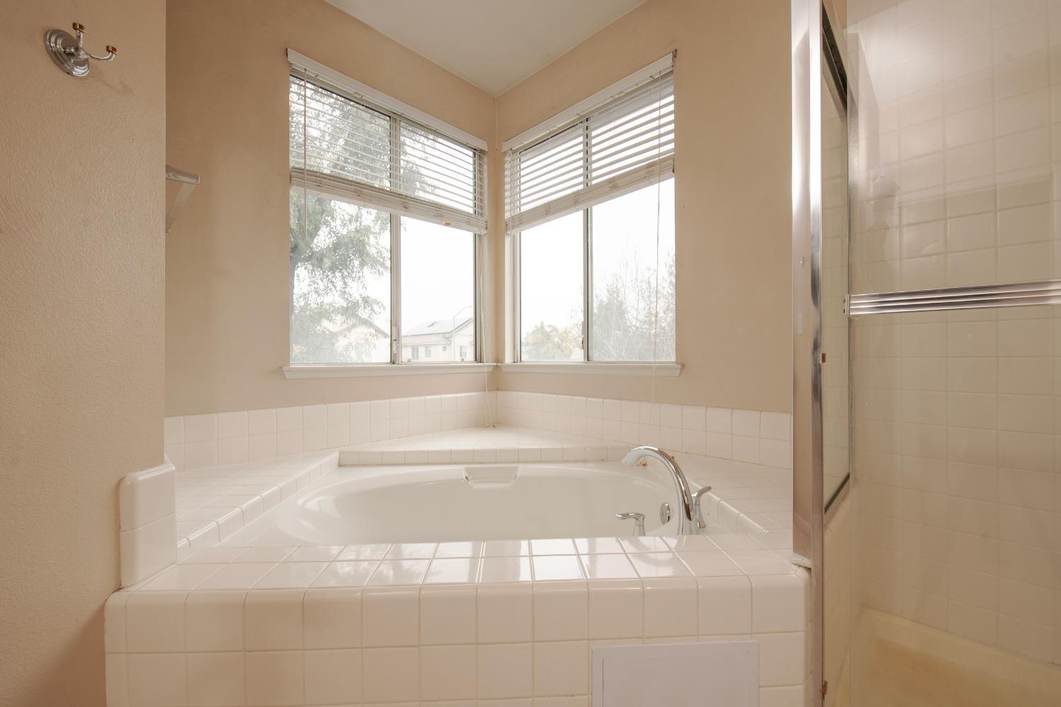 1361 Birch Avenue Clovis, CA 93611 - Photo 40 of 43 a white bath tub sitting in a bathroom next to a window